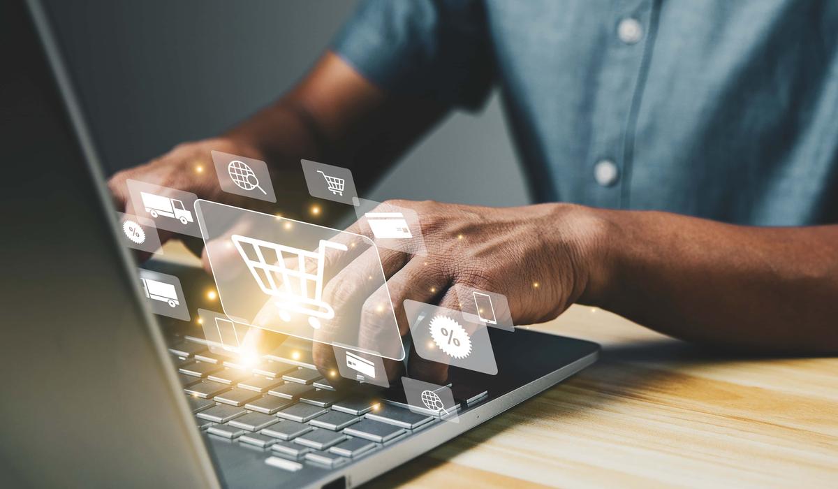 Shopper using computer laptop to input order with trolley credit card delivery truck for online shopping and e commerce technology concept