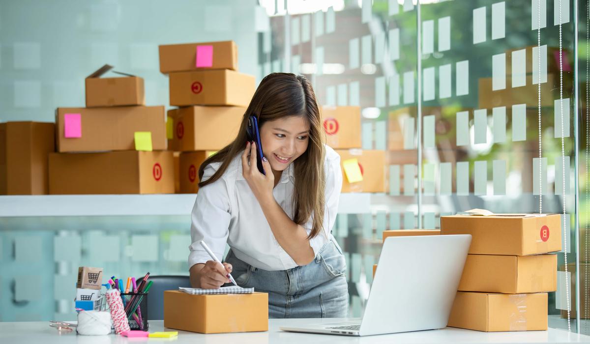 woman on cell phone surrounded by boxes