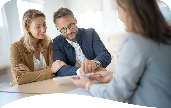 a husband and wife sitting at a table with a financial professional