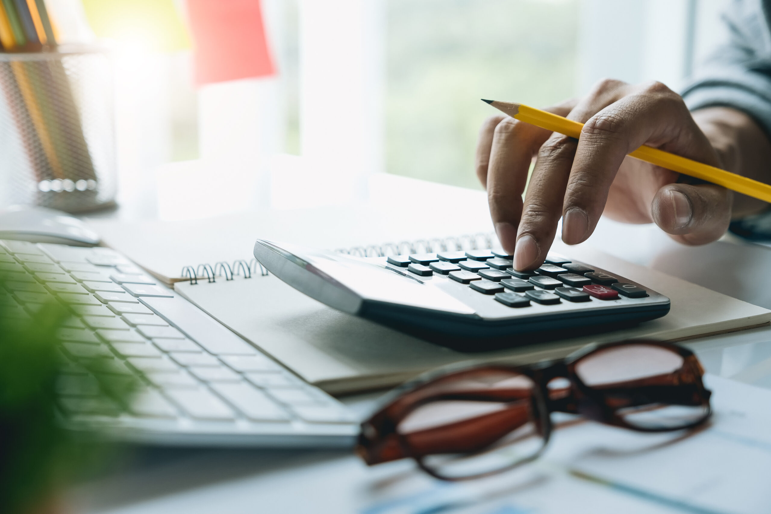man with calculator counting making notes at office hand is writes in a notebook