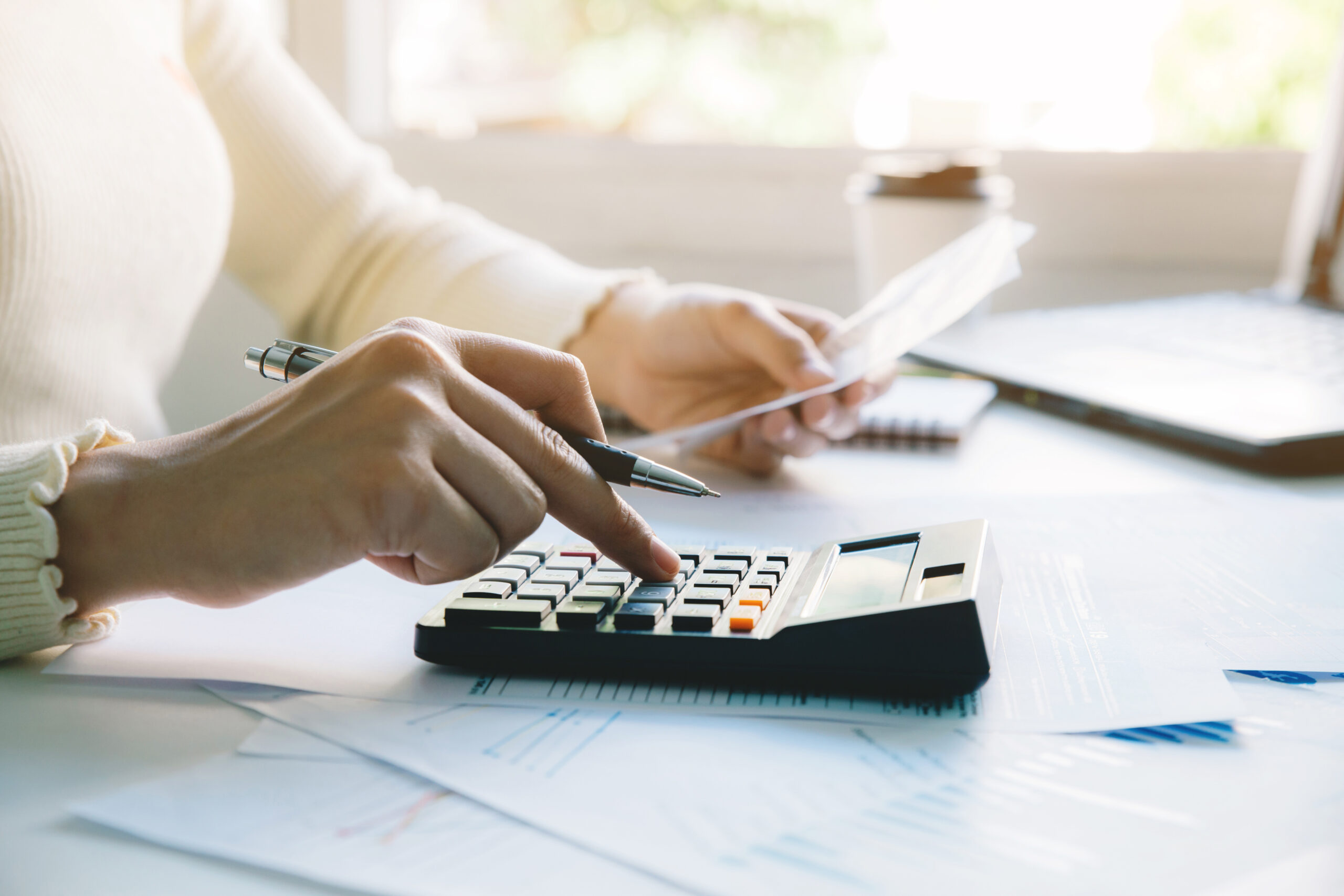women calculate taxes at home. using calculator